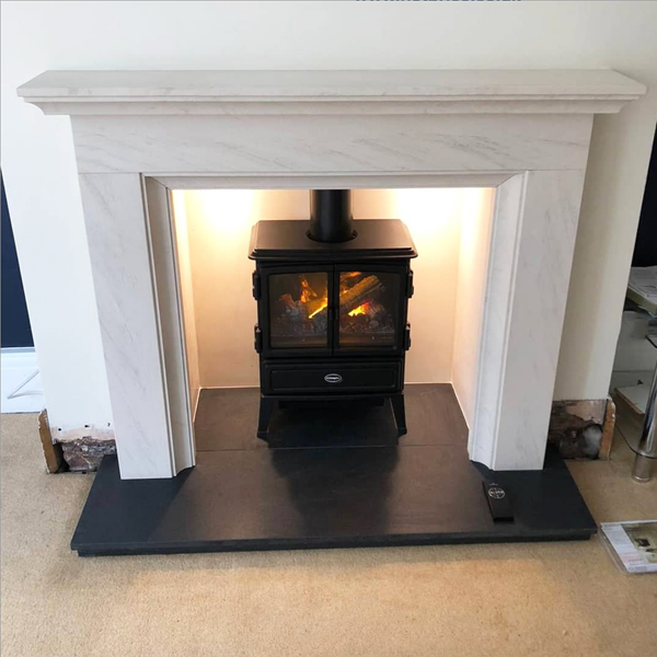 Limestone fireplace surround with electric stove in Manchester